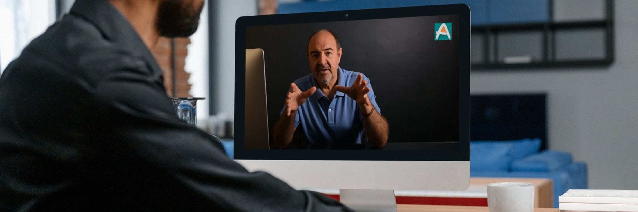 Student at a desk watching Martin Osner teach an online art class