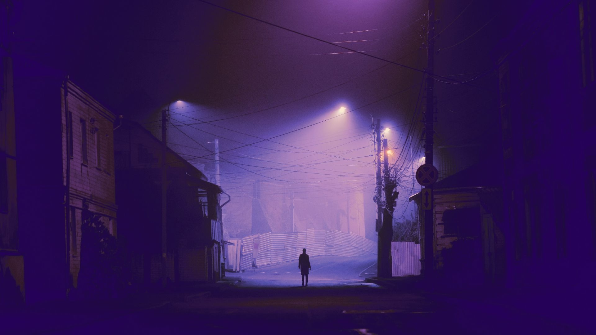A lonely person standing alone at night under street lights. Depicts the lonely art of art