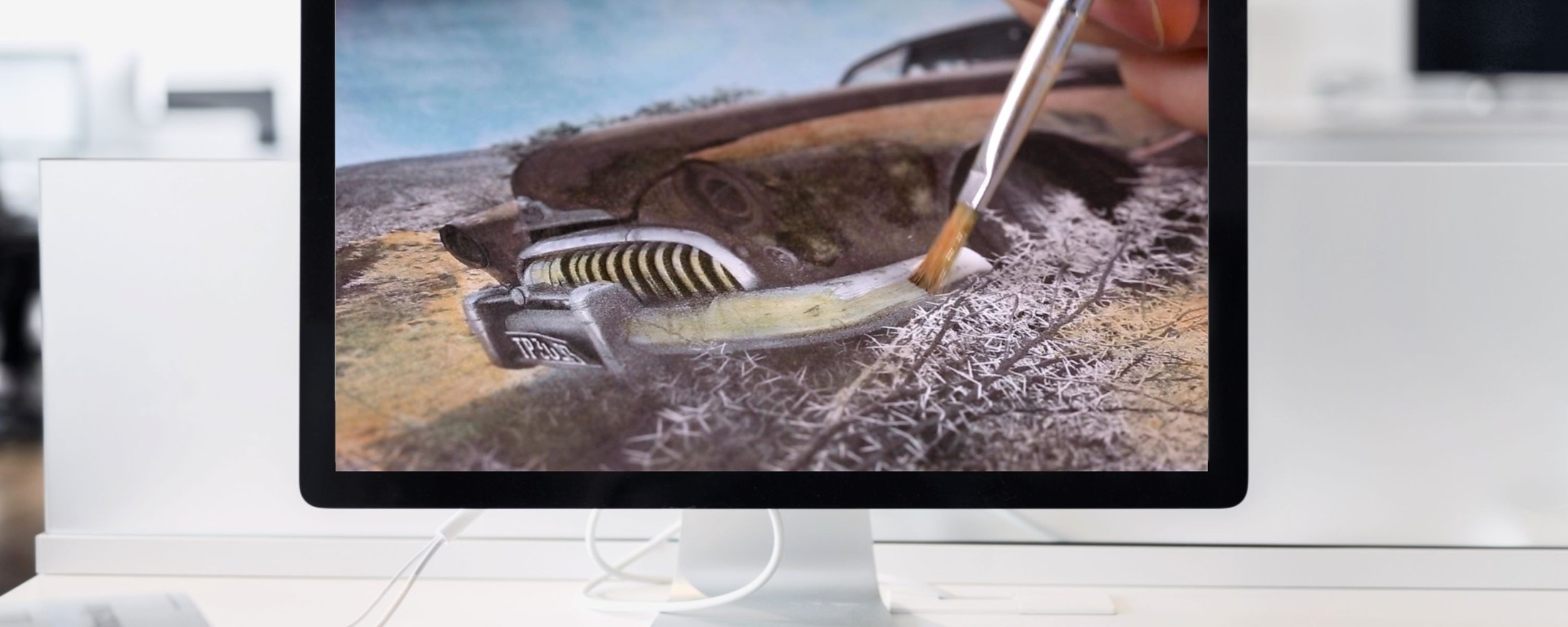 Painting over a photograph of an old car on a screen in Photoshop