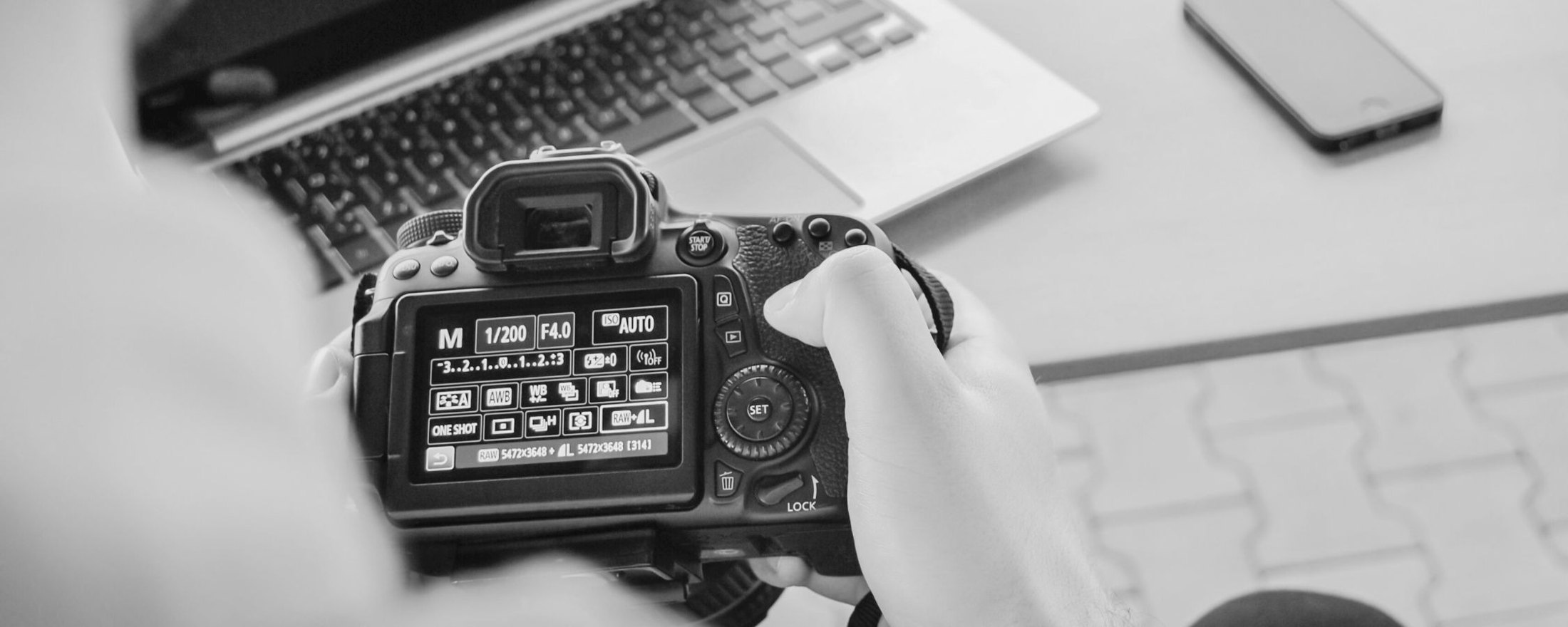 Photographer reviewing a shot on the back screen of a camera at a desk