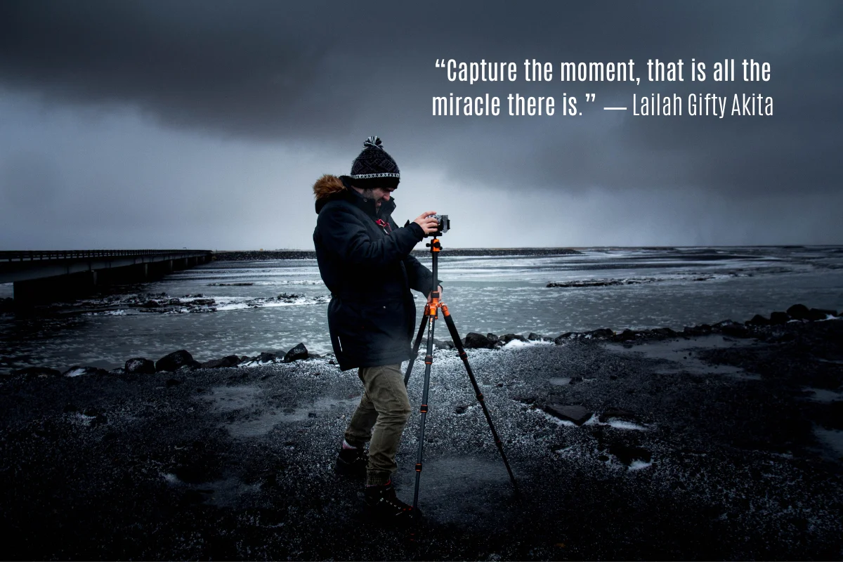 Photographer with a tripod on a stormy shoreline, with a quote on capture